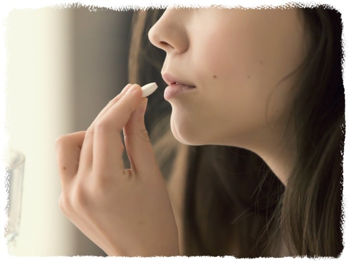 image of a woman taking probiotic supplements