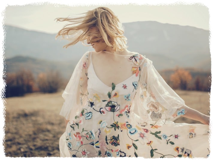 A blonde wearing a white dress walking through a field how to love yourself.